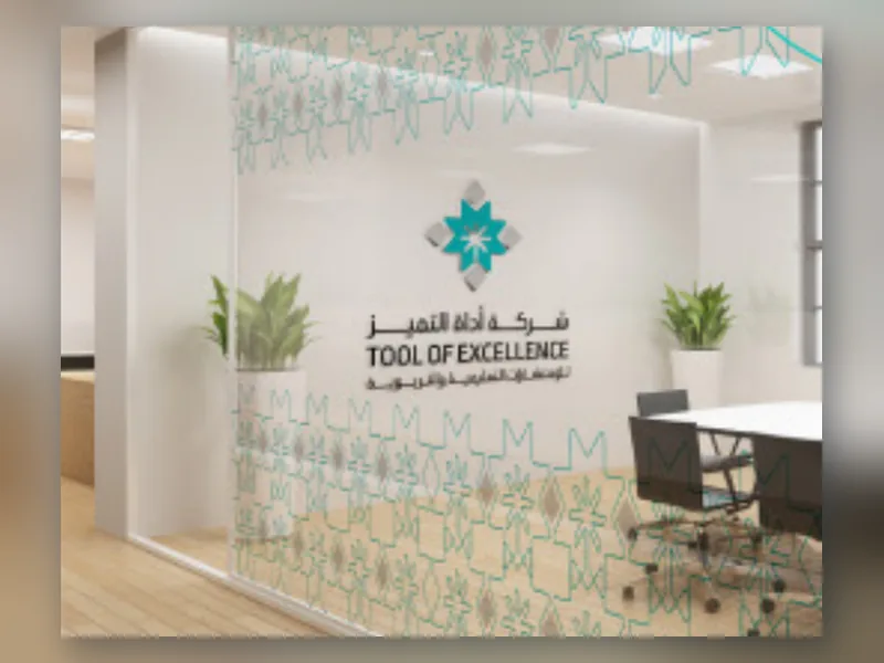 قاطع زجاجي في مكتب عليه ملصقات شركة أداة التميز