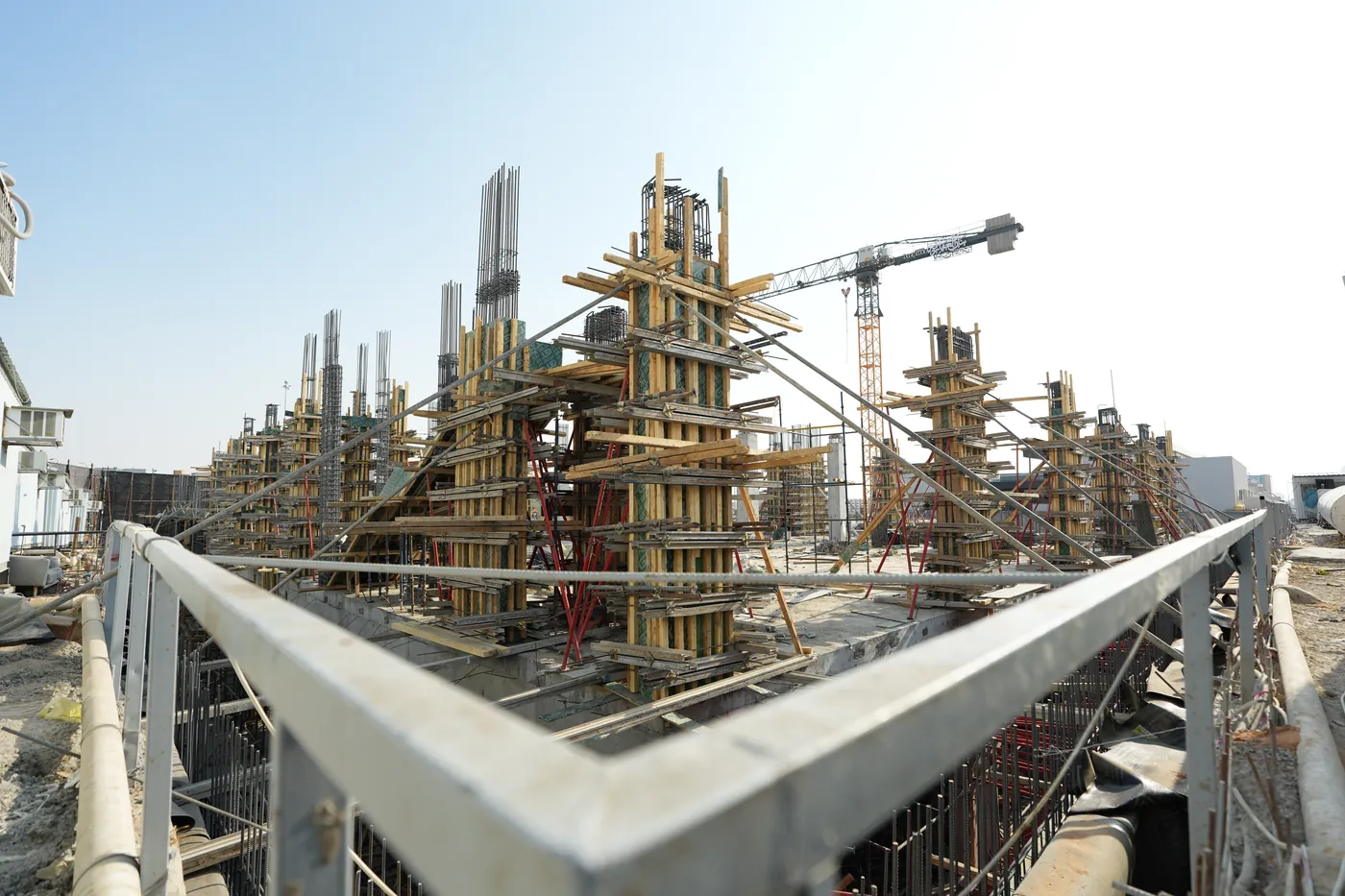A construction site: columns, formwork, and a crane, from our construction photography