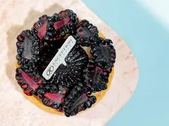 A blackberry tart on pink stone, from Exception Sweets